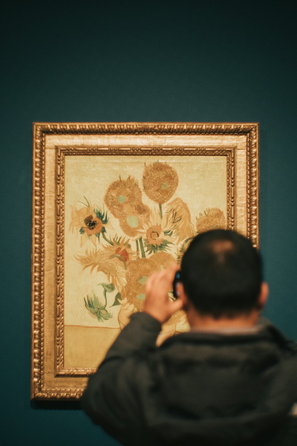 Visitor uses a smartphone to photograph a Van Gogh painting.