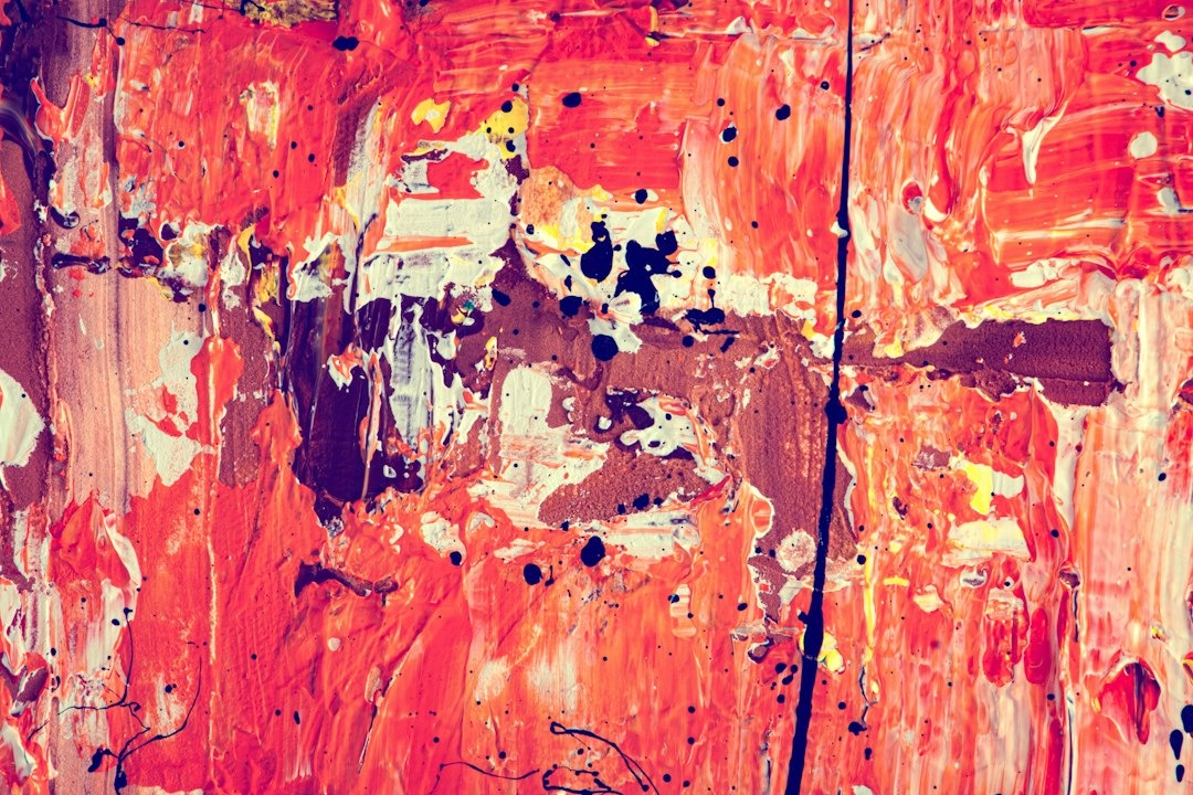 Abstract painting with textured layers of red and orange paint.